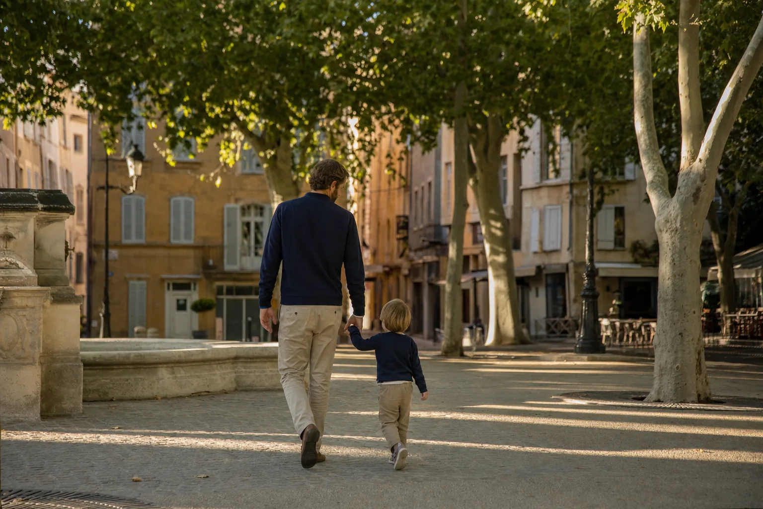 Parent et enfant sur un cours planté de platanes à Aix-en-Provence