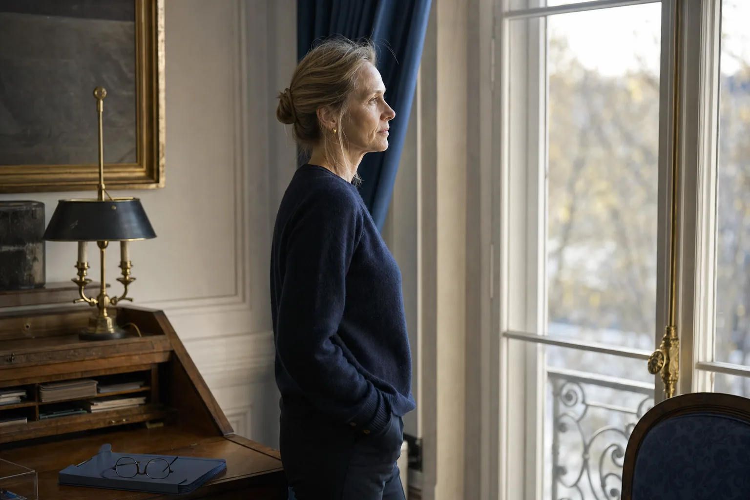 Femme consultant son dossier de prestation compensatoire devant une fenêtre